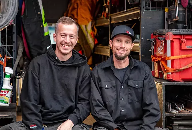 Two agricultural overhead door and opener repairmen sitting in their truck after doing the preventive maintenance on farm buildings of Metcalfe, Eastern Ontario.